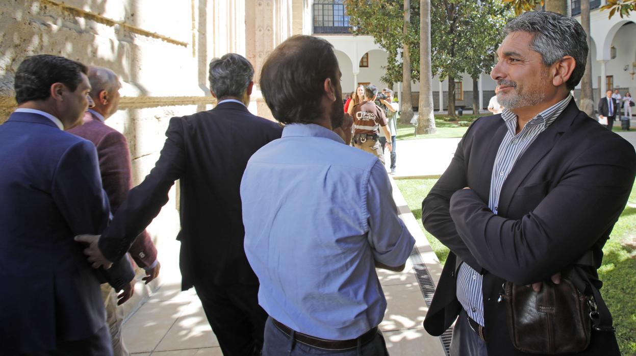 Juan José Cortés esperando al presidente andaluz que lo esquiva en uno de los patios del Parlamento