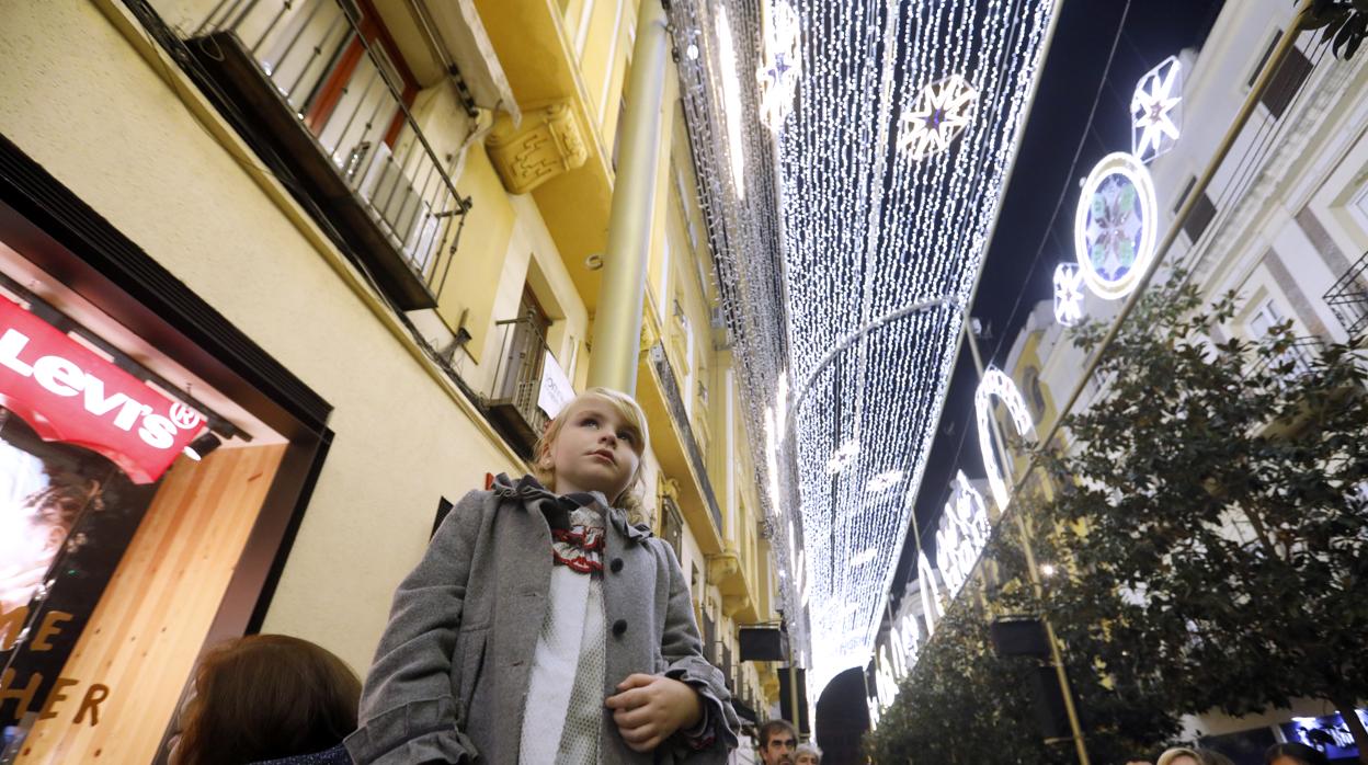 Una niña observa el espectáculo de luz de la calle Cruz Conde de Córdoba
