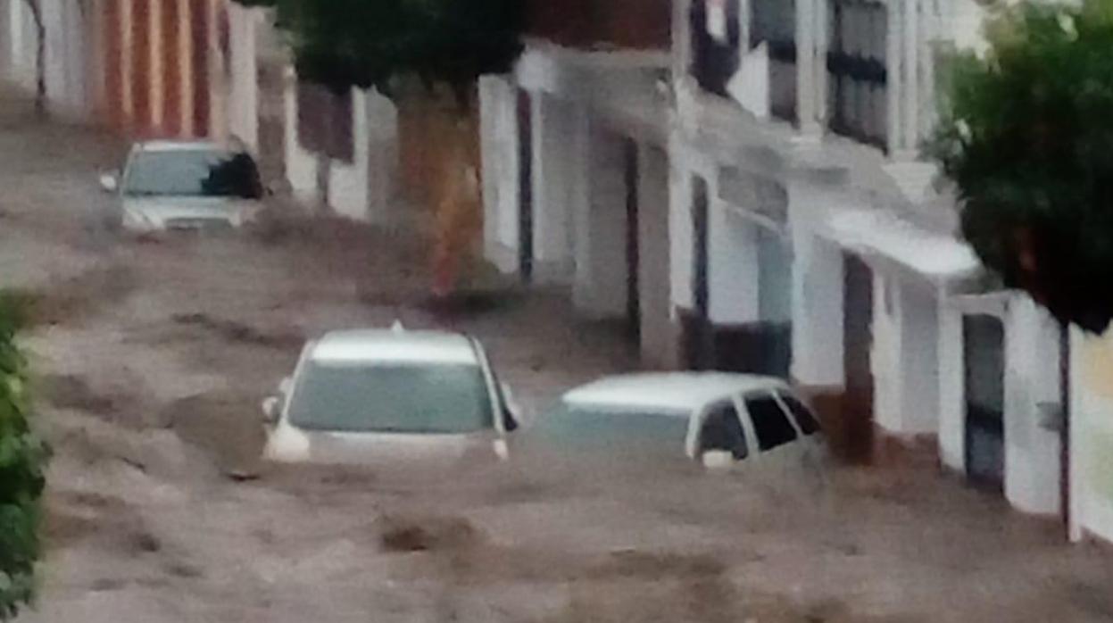 Varios coches atrapados en el agua en una calle en Nerva