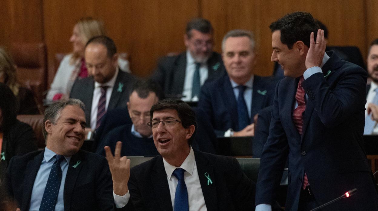 El presidente de la Junta, Juanma Moreno, junto a Bendodo y Marín gesticulando con los diputados del PSOE, sentados en la bancada de enfrente