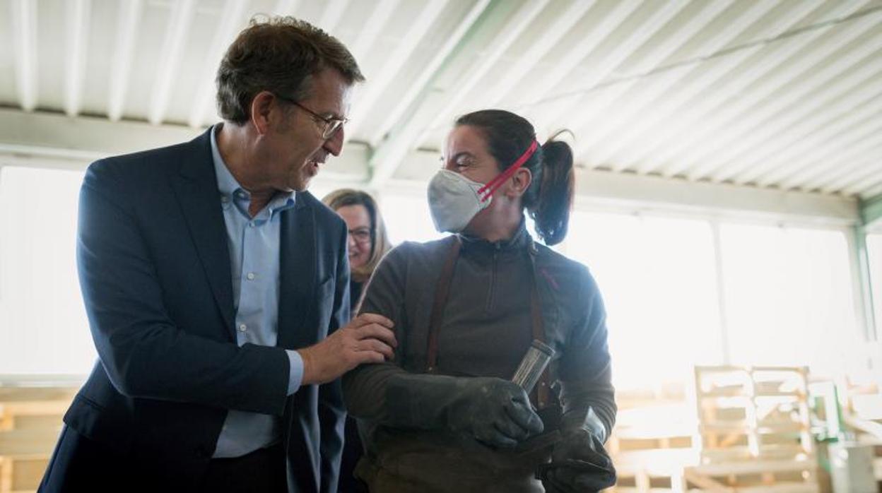 El presidente de la Xunta, Alberto Núñez Feijóo, conversa con una trabajadora en Carballeda de Valdeorras