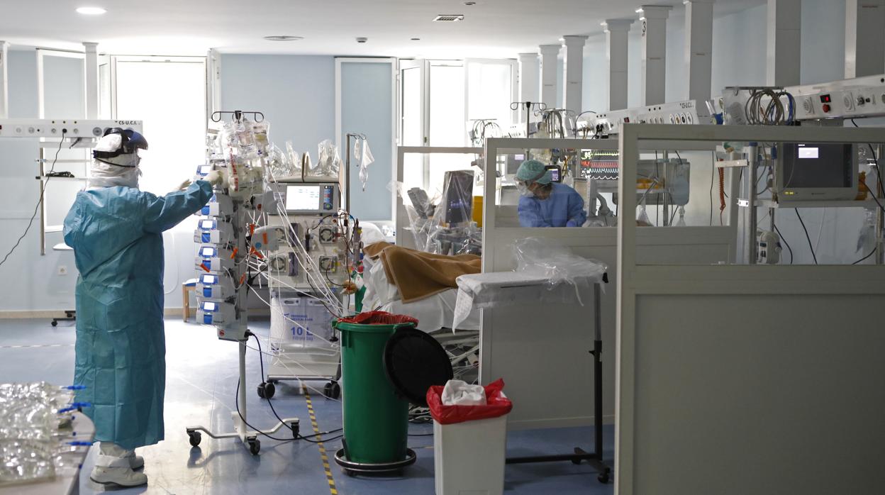 Una doctora atiende a un paciente en la UCI para enfermos de coronavirus en la Cruz Roja de Córdoba