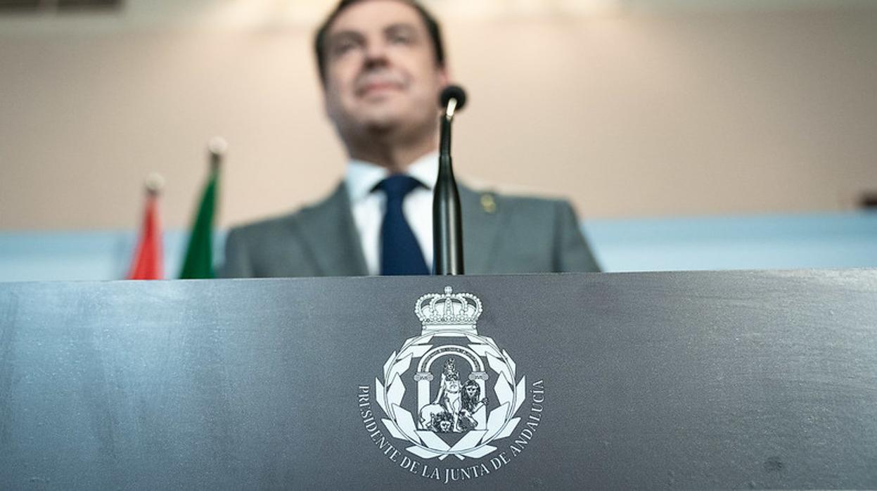 Juanma Moreno compareció el domingo pasado con su escudo impreso en el atril desde el que se dirigió