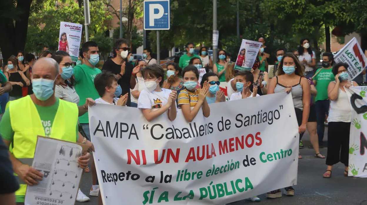 Un grupo de manifestantes con una pancarta referida a un colegio de Córdoba