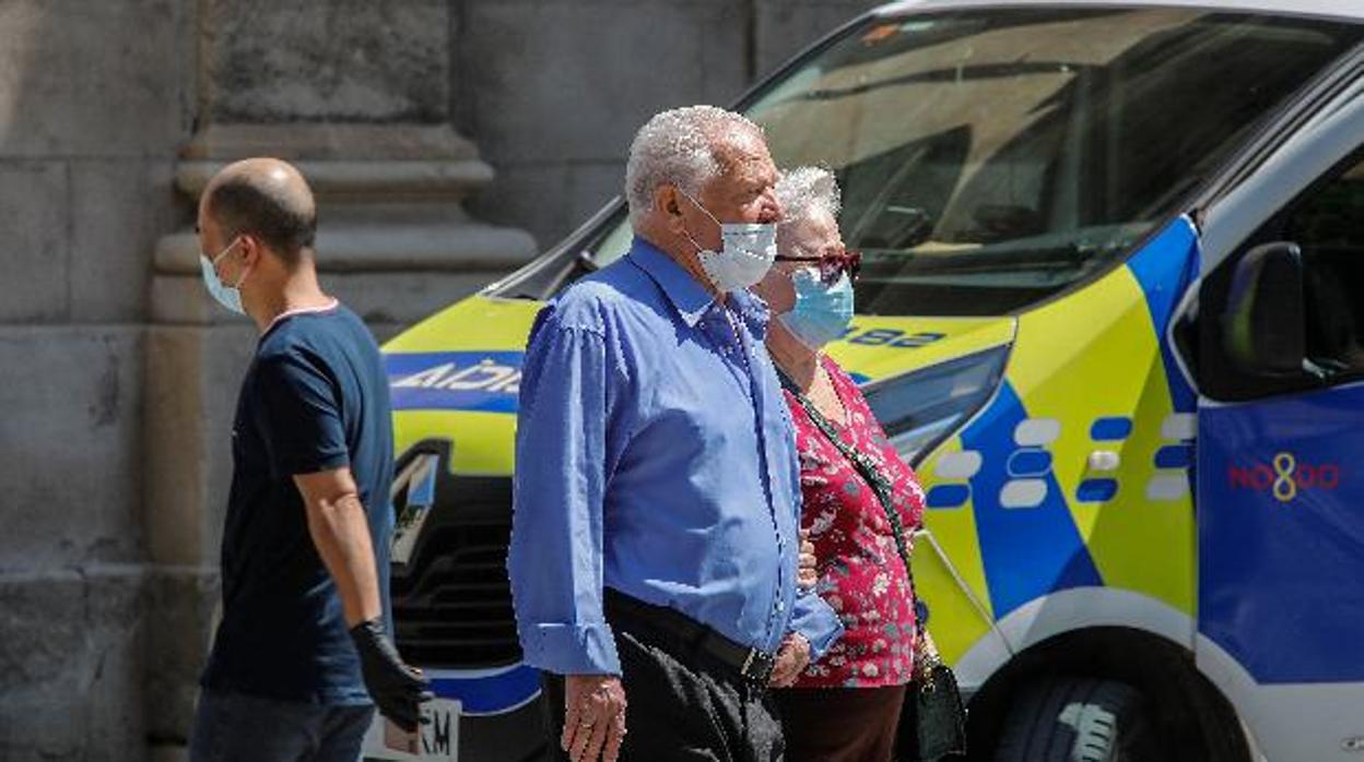 Dos personas mayores con sus mascarillas