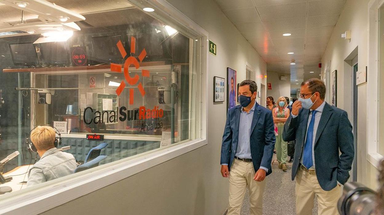 El presidente de la Junta, Juanma Moreno, junto al director general de la RTVA, Juande Mellado, este lunes