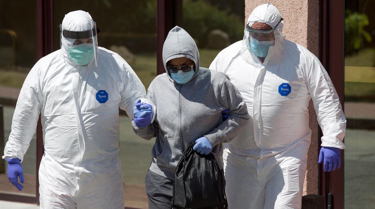 Personal sanitario traslada desde el Centro de Acogida de Málaga, donde se registró un brote