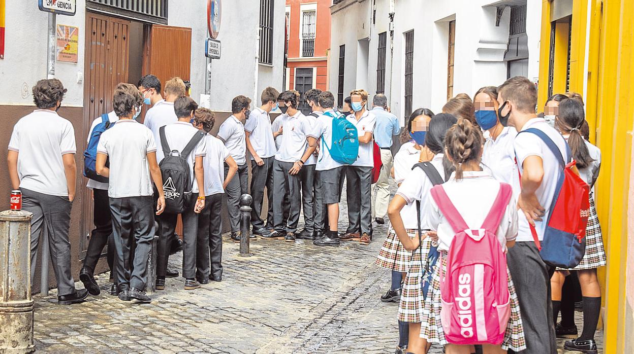 Alumnos de un colegio concertado de Sevilal esperan para entrar en clase