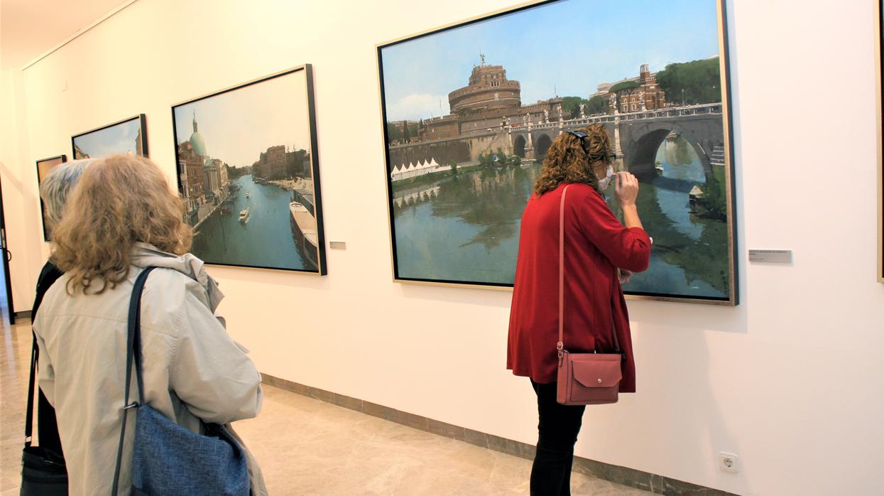 Una mujer mira atentamente uno de los cuadros de la exposición de Francisco Escalera