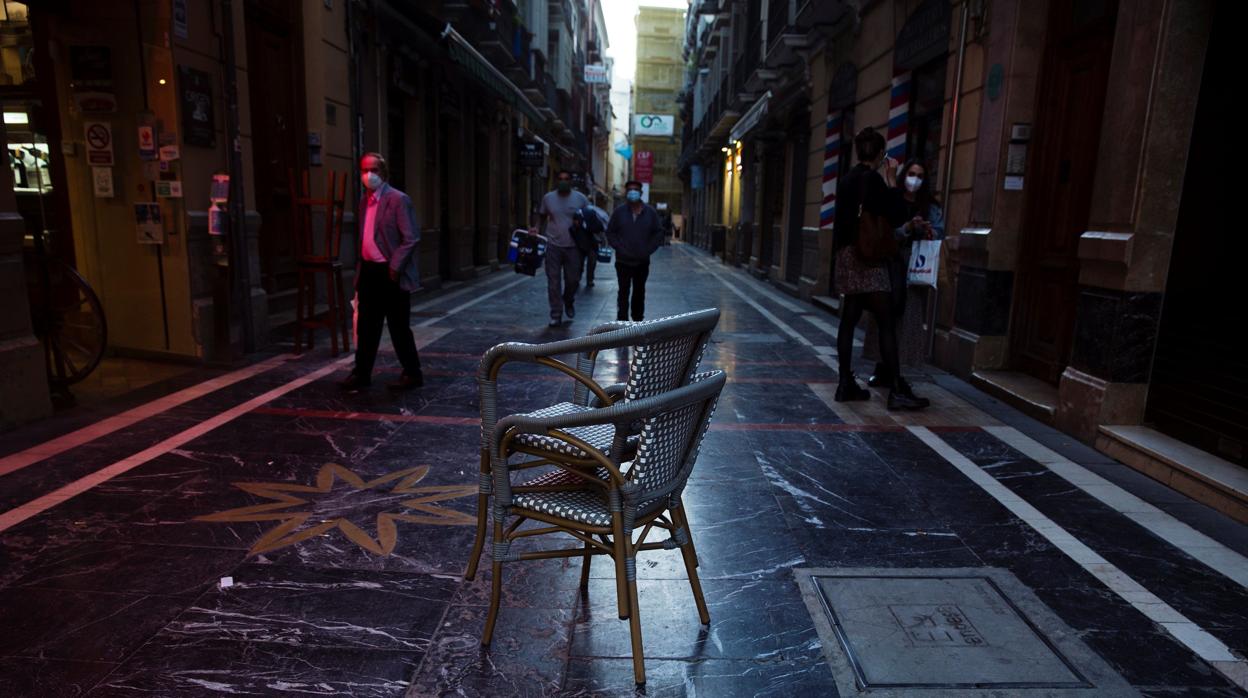 Aspecto que presentaba ayer Málaga por la tarde con sillas de un restaurante para ser recogidas
