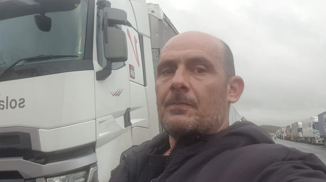 Rafael Rojano delante de su camión este miércoles en la M-20 con la fila de vehículos parados a su espalda