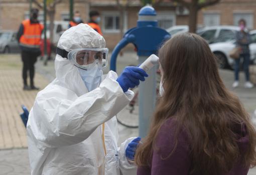 Un sanitario toma la temperatura a una de las participantes en el cribado