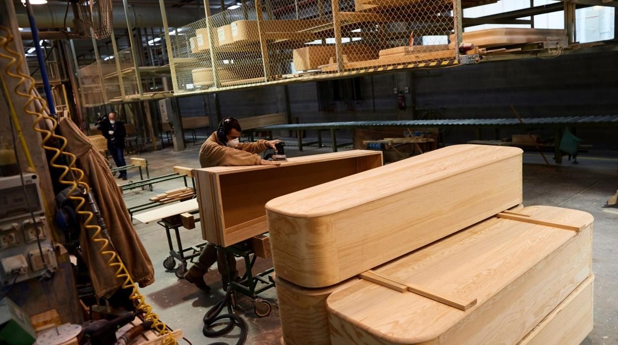 Un trabajador prepara un ataúd en una fábrica