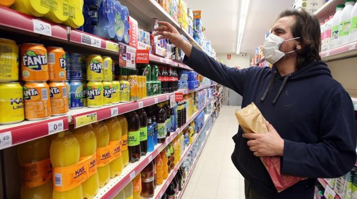 Un cliente compra en una tienda con la mascarilla puesta