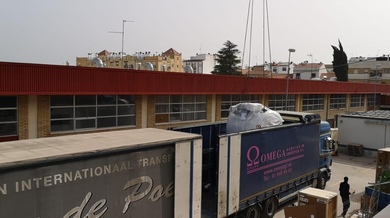 Operarios extraen de un camión la unida de resonancia magnética en el Hospital Valle de los Pedroches