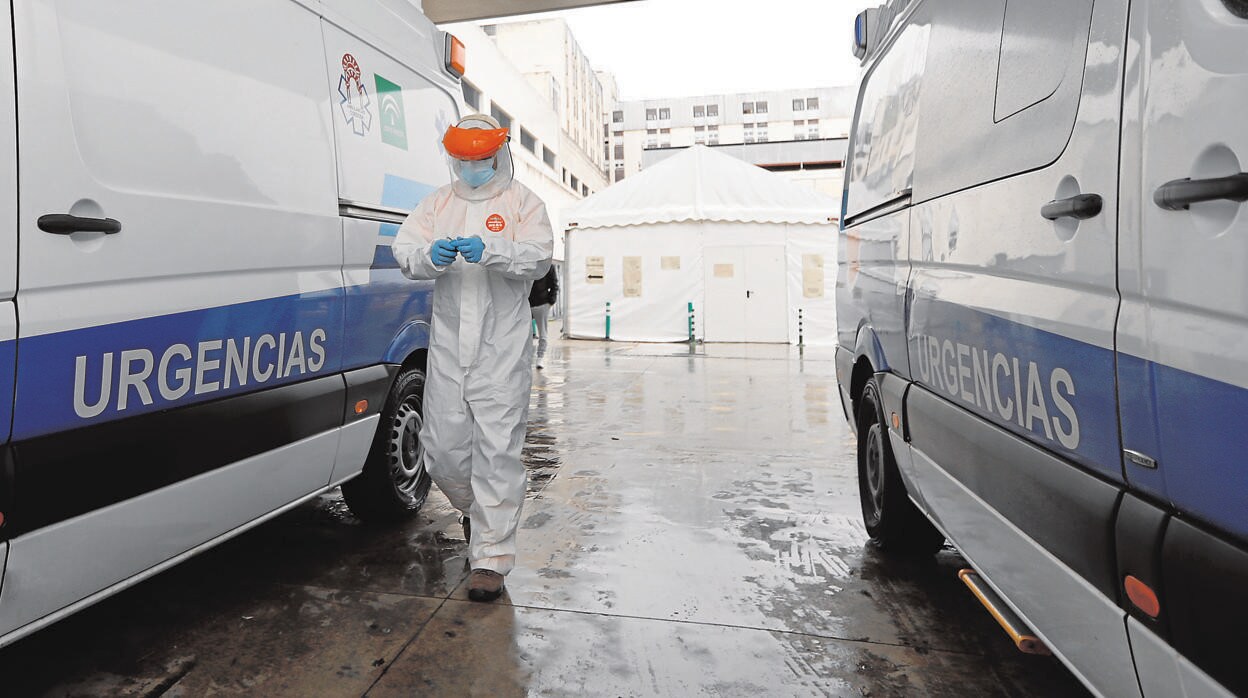 Un sanitario entre dos ambulancias en el exterior del Hospital Reina Sofía