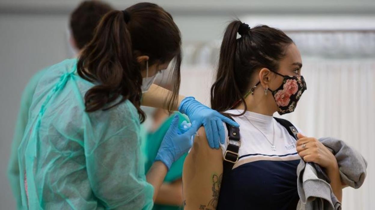 Una enfermera inyecta una dosis del suero de AstraZeneca a una mujer en un centro de vacunación de Sevilla