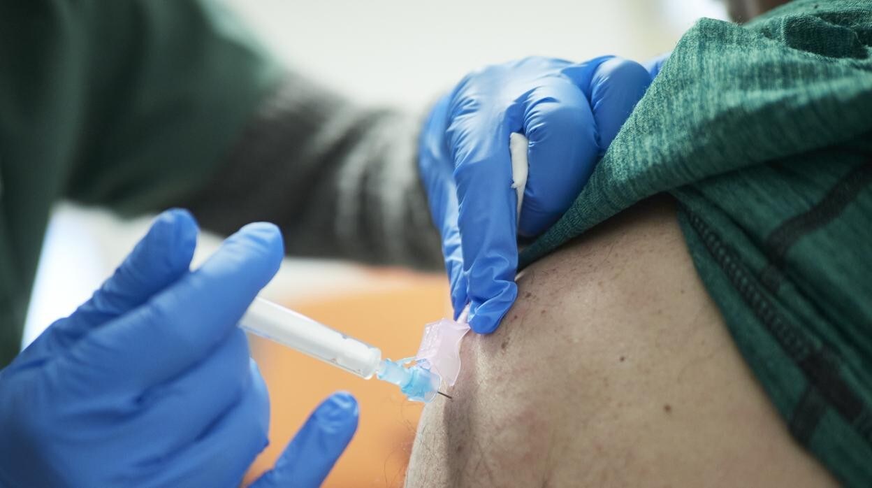 Un sanitario vacuna a una persona en un centro de salud de Córdoba