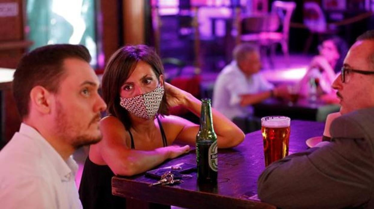 Clientes en el velador de un bar por la noche