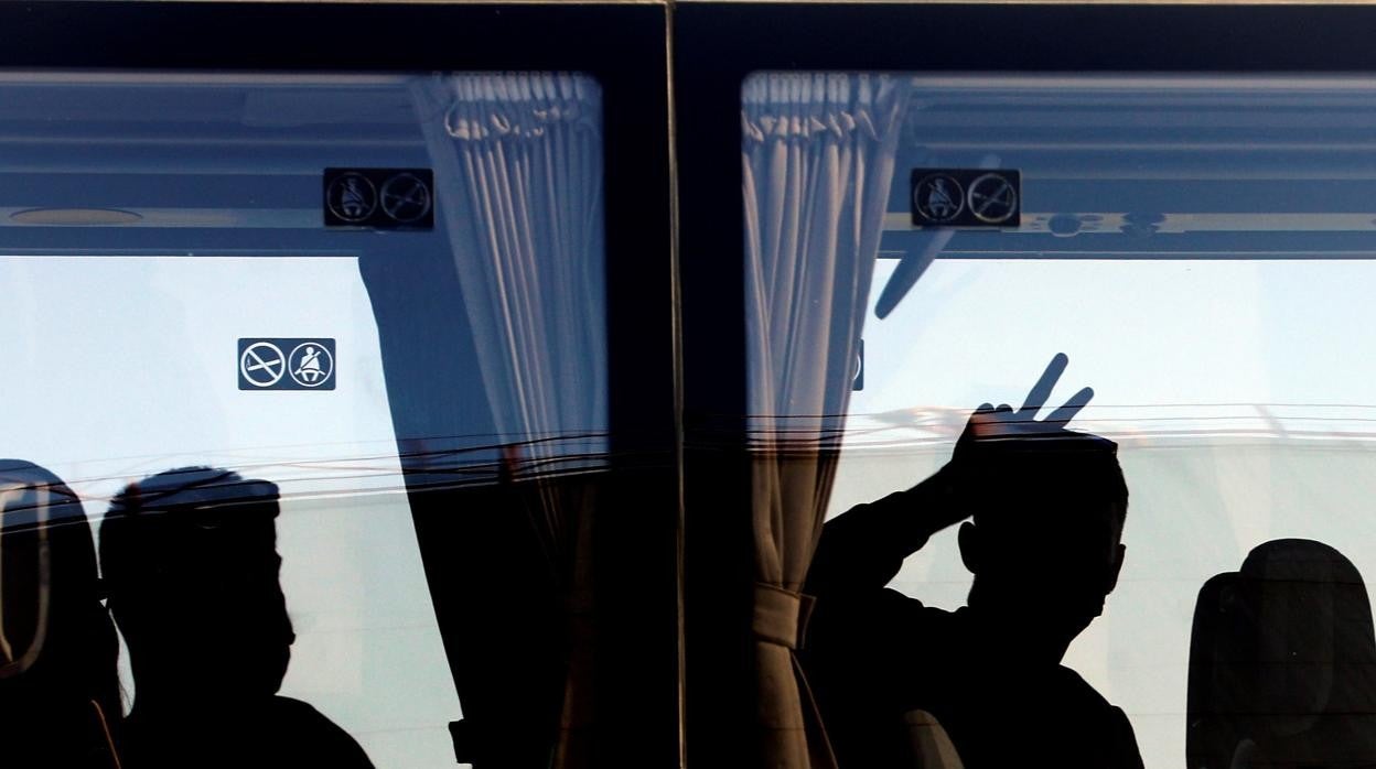 Un joven hace la señal de la victoria tras subir al autobús