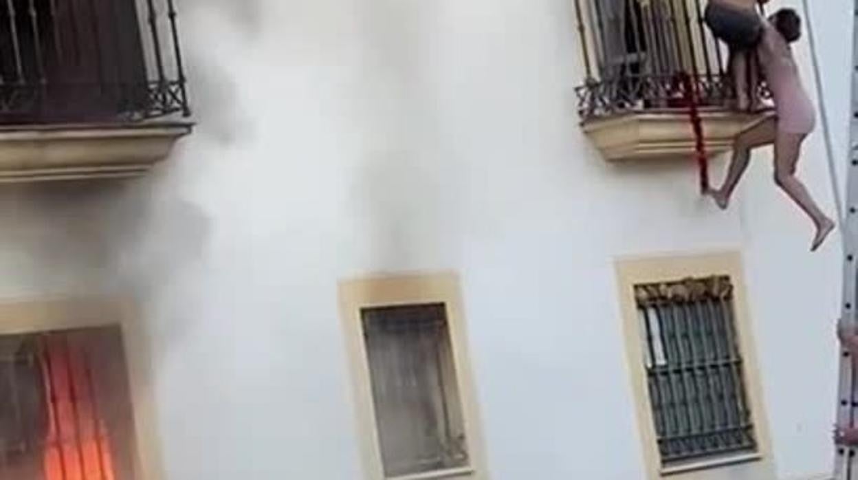 Un joven sujeta a una chica que cuelga de un balcón para escapar del fuego