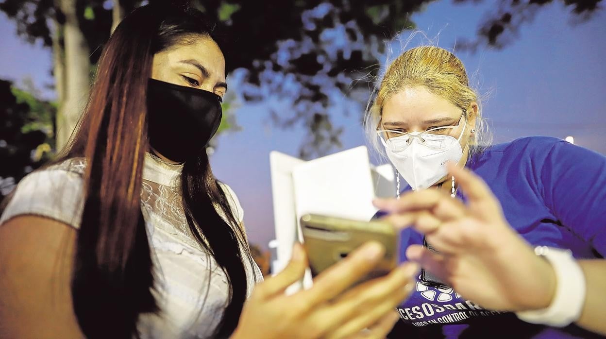 Una joven enseña su pasaporte covid