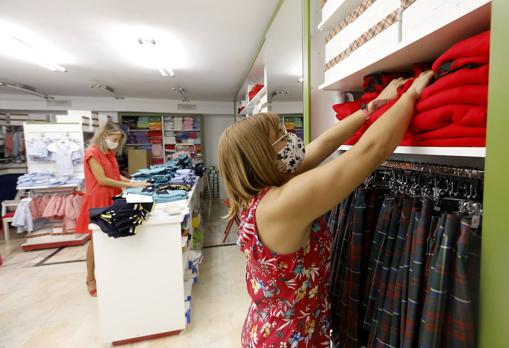 Una mujer mira uniformes escolares en una tienda del Centro de Córdoba