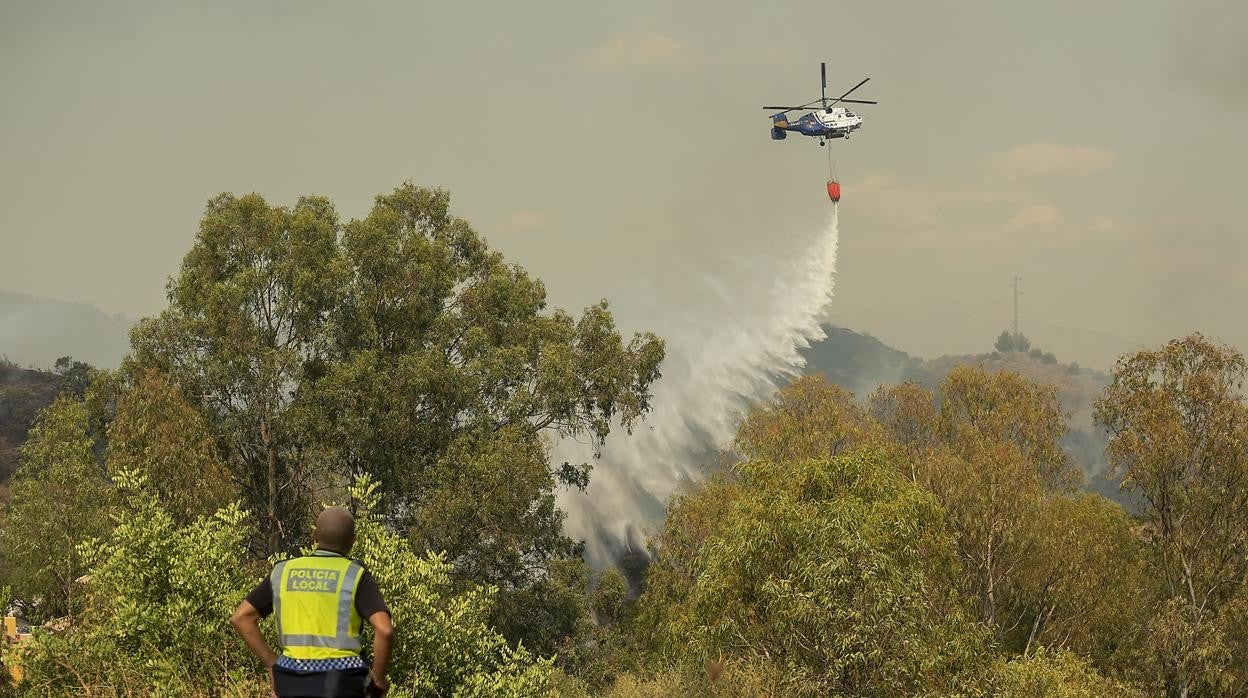 Un helicóptero descarga en el fuego de Sierra Bermeja