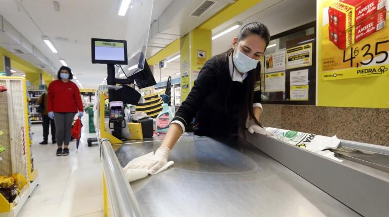 Una empleada de un supermercado Piedra limpia la zona de caja de un establecimiento en abril del año pasado