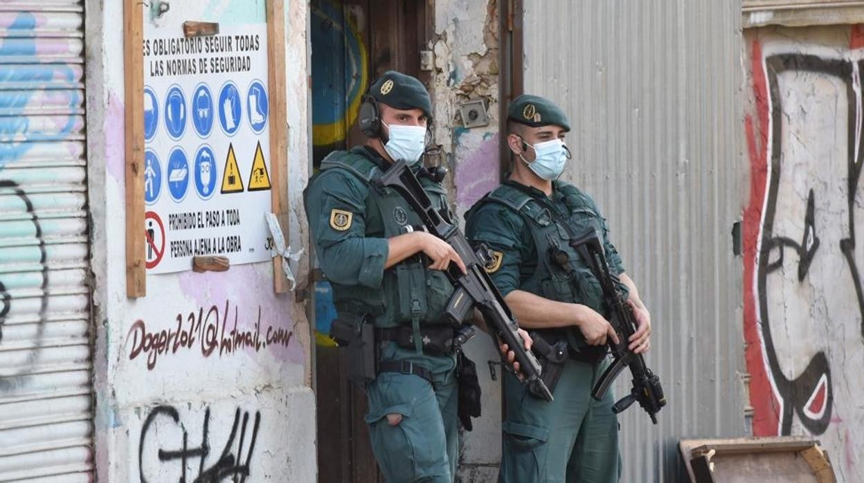 Dos agentes custodian el acceso a un edifico durante los registros