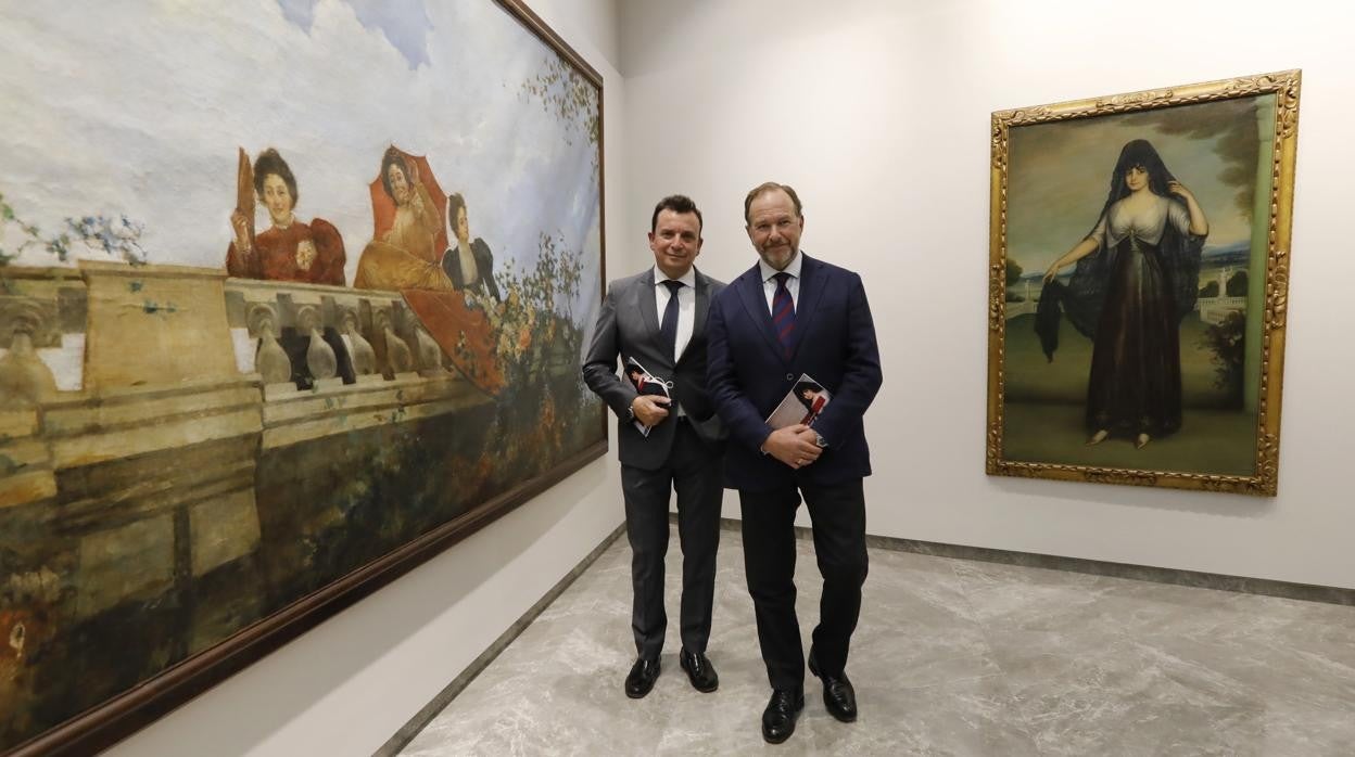 El presidente de la Fundación Caja Rural del Sur, a la derecha, con dos de los cuadros expuestos