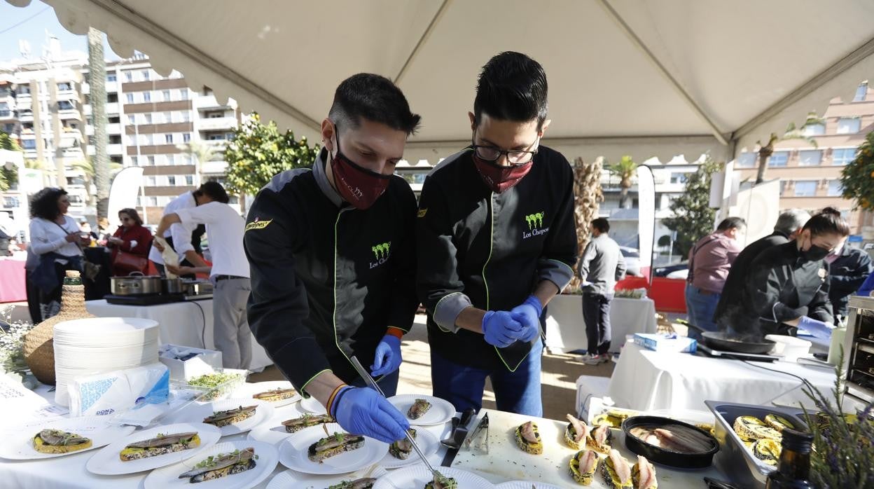 Dos cocineros en los Jardines de la Victoria elaboran tapas dentro del evento callejero de Califato Gourmet