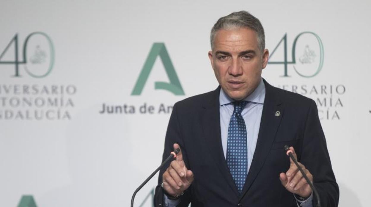 El consejero de Hacienda, con dos bolsas con toda la documentación de la negociación del Presupuesto, junto a Elías Bendodo, este martes en el Palacio de San Telmo