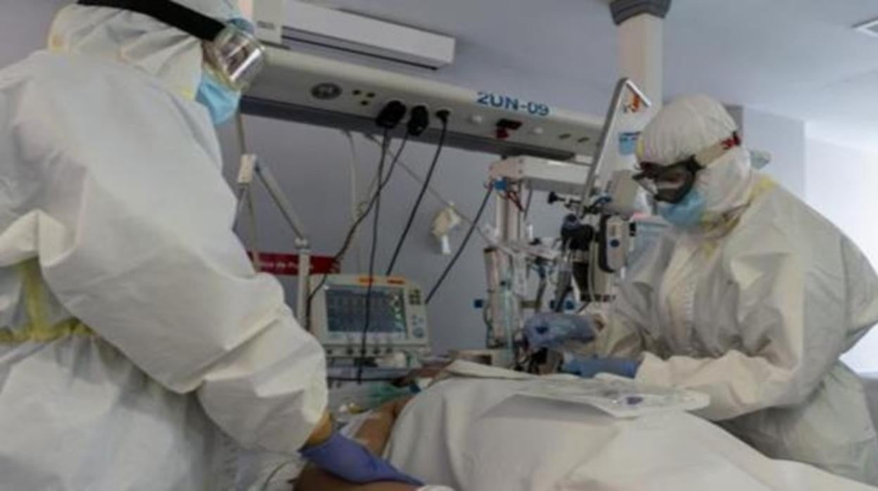 Dos sanitarios atienden a un paciente en la UCI