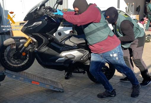 Agentes se llevan una de las motos intervenidas en el registro de la casa de este narco