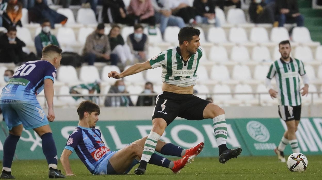 El delantero del Córdoba CF Willy Ledesma protege el balón ante dos rivales del Coria
