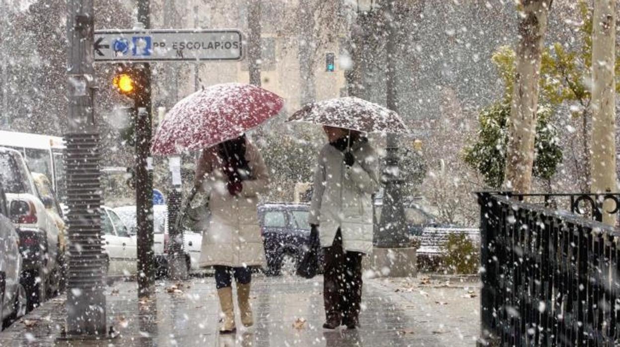 Dos mujeres caminan por Granada capital mientras nieva