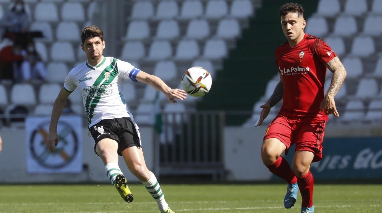 El capitán del Córdoba CF, Javi Flores, golpea el balón en una acción ante el CD Mensajero