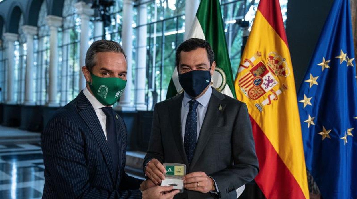 El presidente de la Junta de Andalucía, Juanma Moreno, a la derecha, junto al consejero de Hacienda, Juan Bravo, tras aprobar los presupuestos de Andalucía para 2021