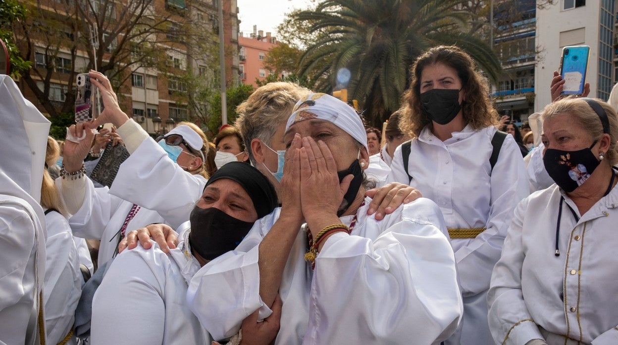 Encarni llora con una compañera durante la salida del Cristo, antes de vendarse los ojos