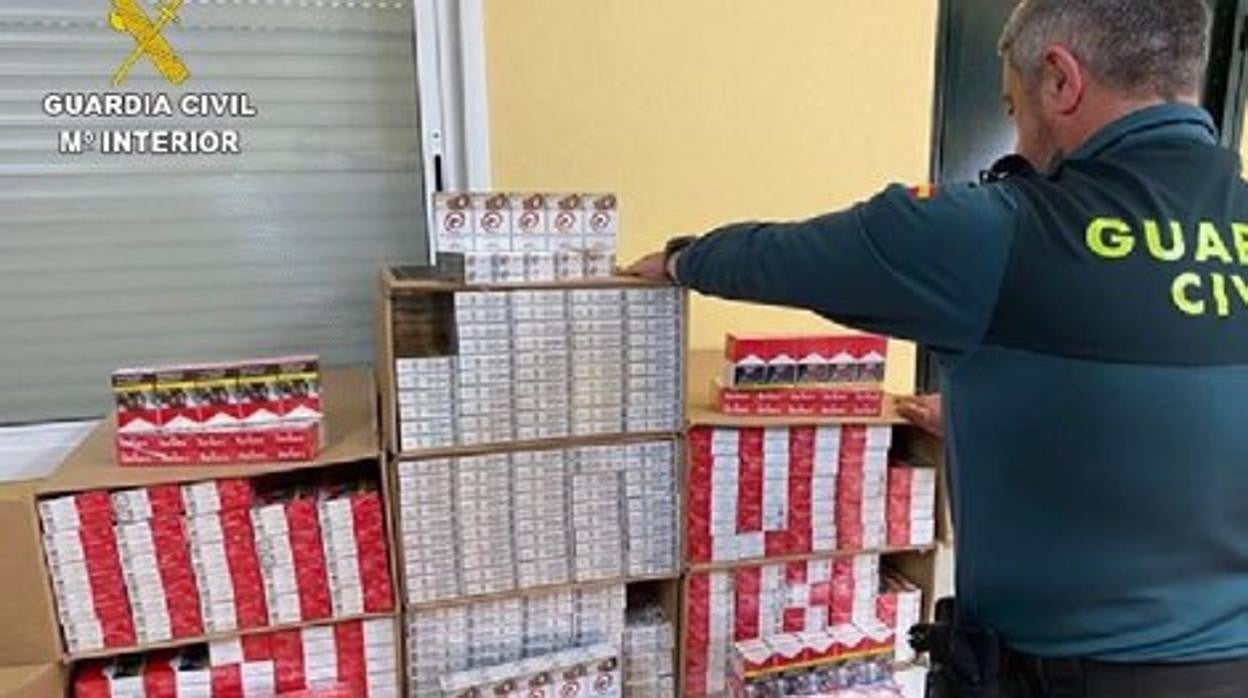 Un guardia civil, junto a parte del tabaco intervenido en Moguer