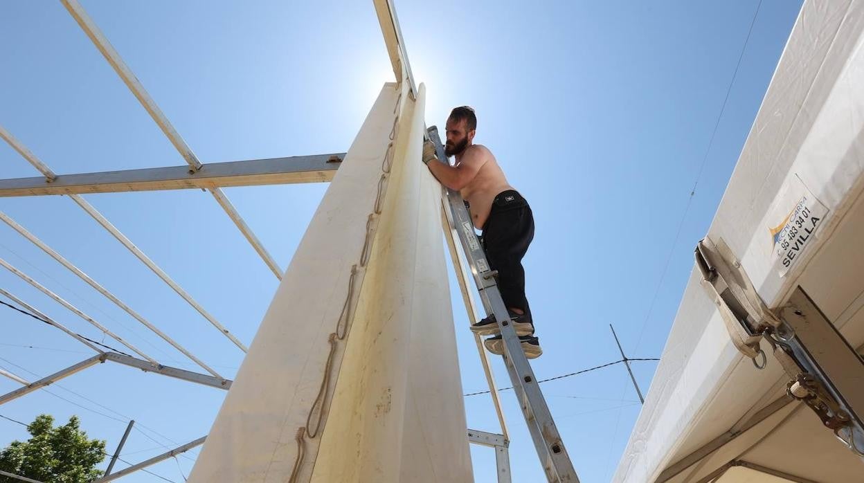 Un operario trabaja en el montaje de una caseta para la Feria de Córdoba a mediodía del lunes