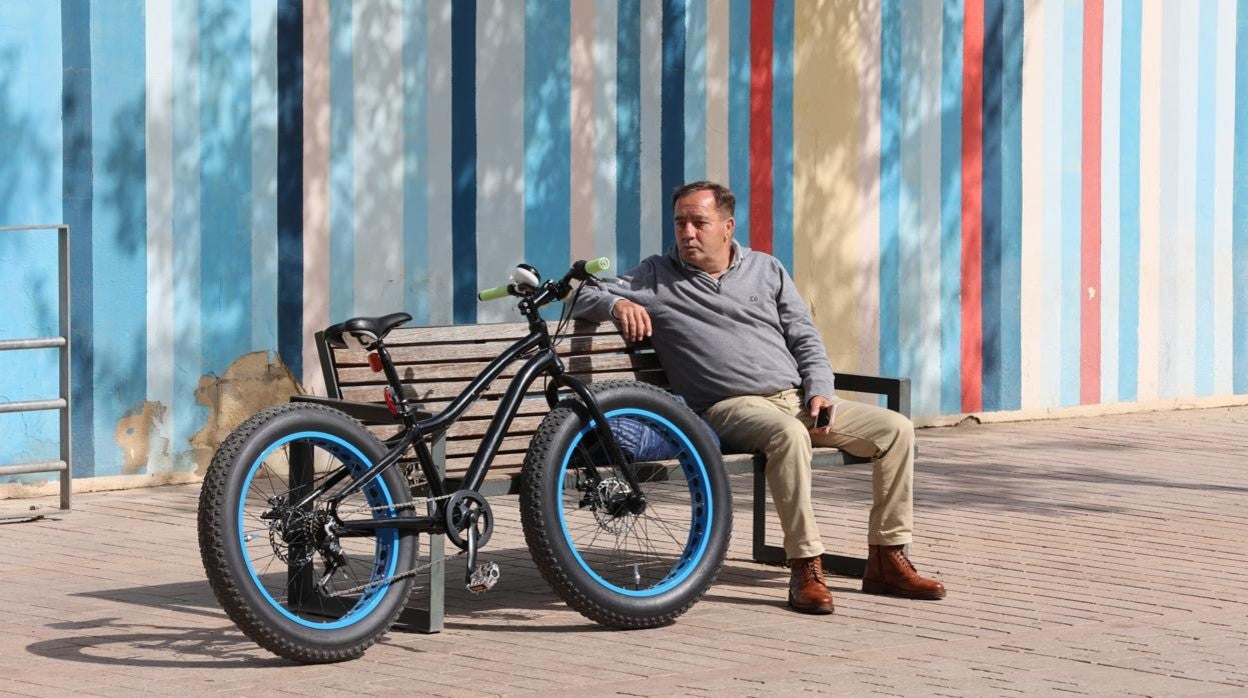 Un hombre descansa junto a una bici