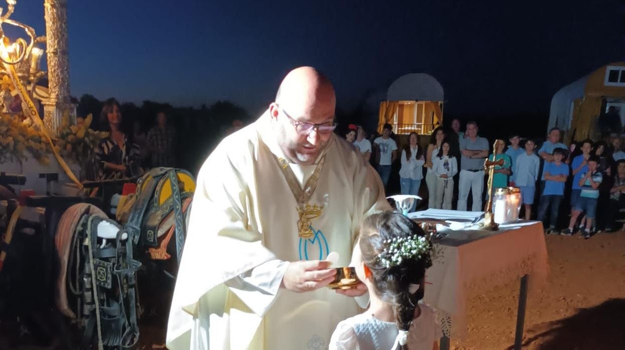 En la imagen, Tomás Pajuelo en el momento de dar la comunión. En el vídeo, cantos para rezarle a la Virgen