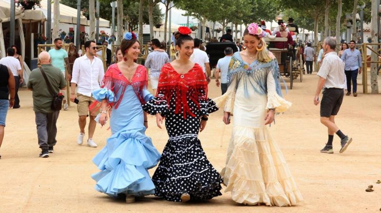 Tres jóvenes vestidas de flamenca en la Feria de Córdoba