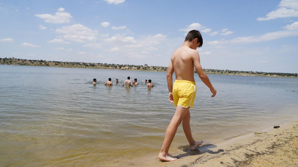 Un niño pasea por el borde de la playa dei nterior de La Colada en El Viso (Córdoba)