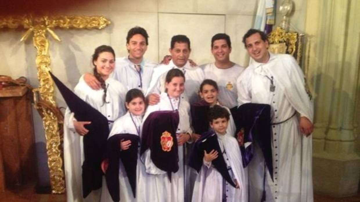 Oliva Soto vestido con la túnica de nazareno de los Gitanos acompañado por su familia