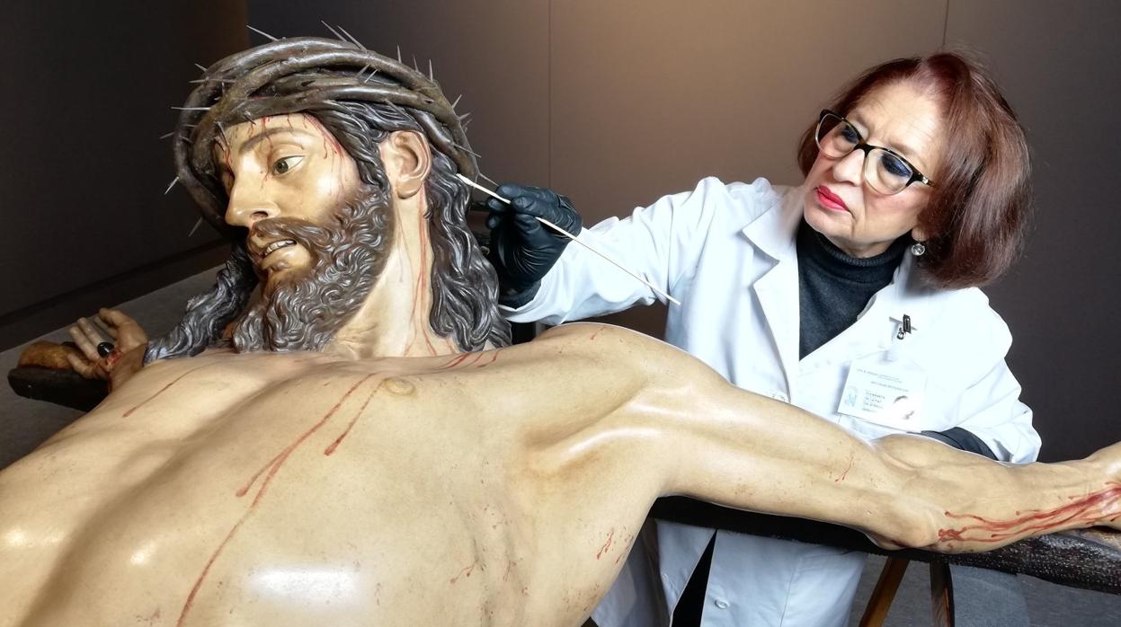 La restauradora Fuensanta de la Paz Calatrava junto al Cristo de la Clemencia