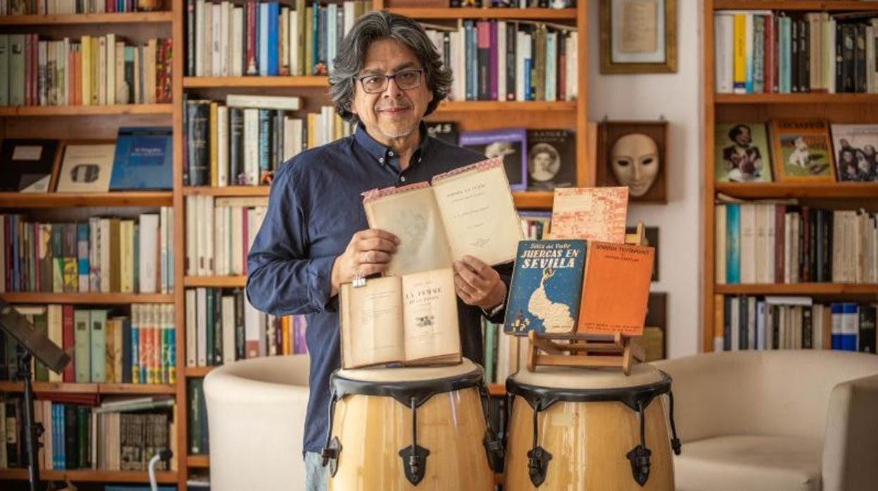 Fernando Iwsaki en su bliblioteca, con algunos de los libros que ha consultado para la serie