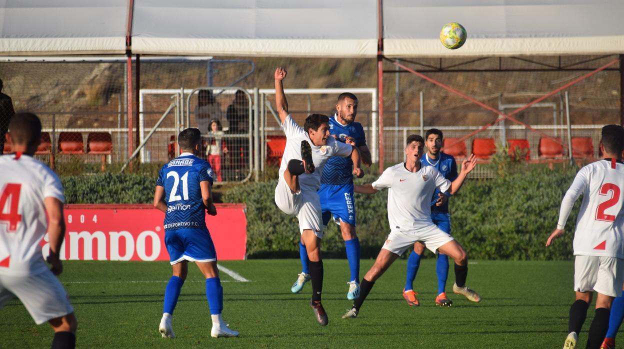 Jaime, del Sevilla C, cae tras pelear un balón con Álex Colorado, del Xerez Deportivo